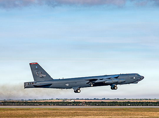 USAF B-52H Stratofortress taking off with landing gear extended over runway