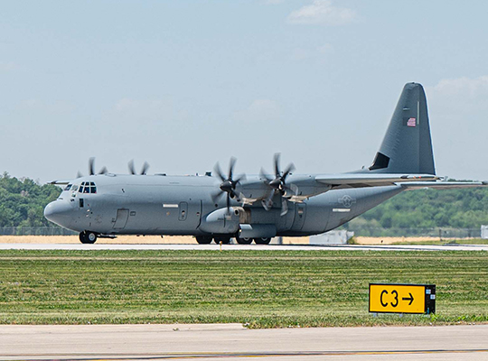 USAF C-130J Hercules taxiing on runway with propellers spinning