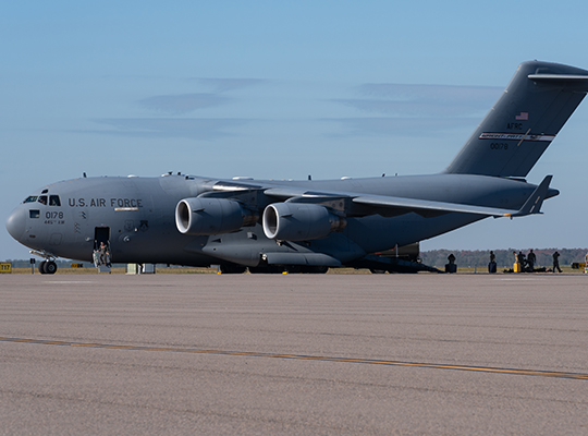 USAF C-17 Globemaster III parked on tarmac with ground crew nearby