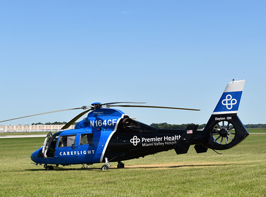 CareFlight medical helicopter flying low over grass field