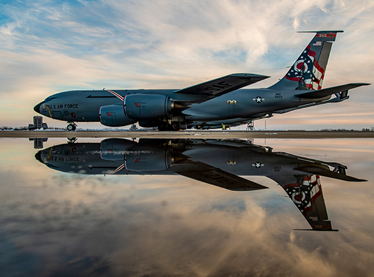 USAF KC-135 Stratotanker parked with reflective surface beneath at sunset