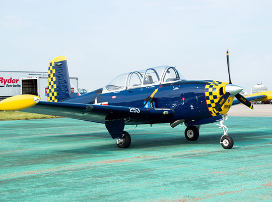T-34 trainer aircraft parked on ramp with checkerboard nose