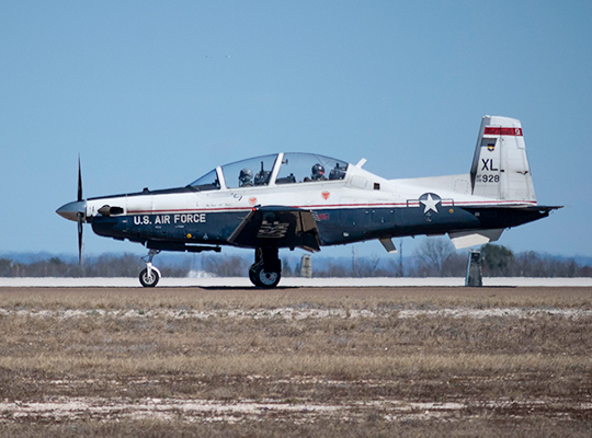 USAF T-6 Texan II parked on runway under clear sky