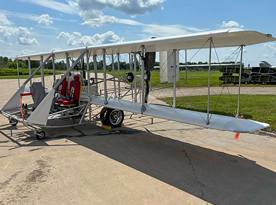 Wright B Flyer replica aircraft parked on ramp with open structure